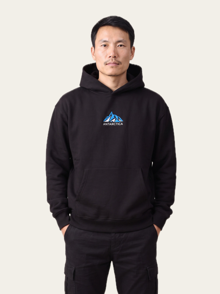 Antarctica hoodie in Noor Black, front, with the minimal Antarctica emblem
