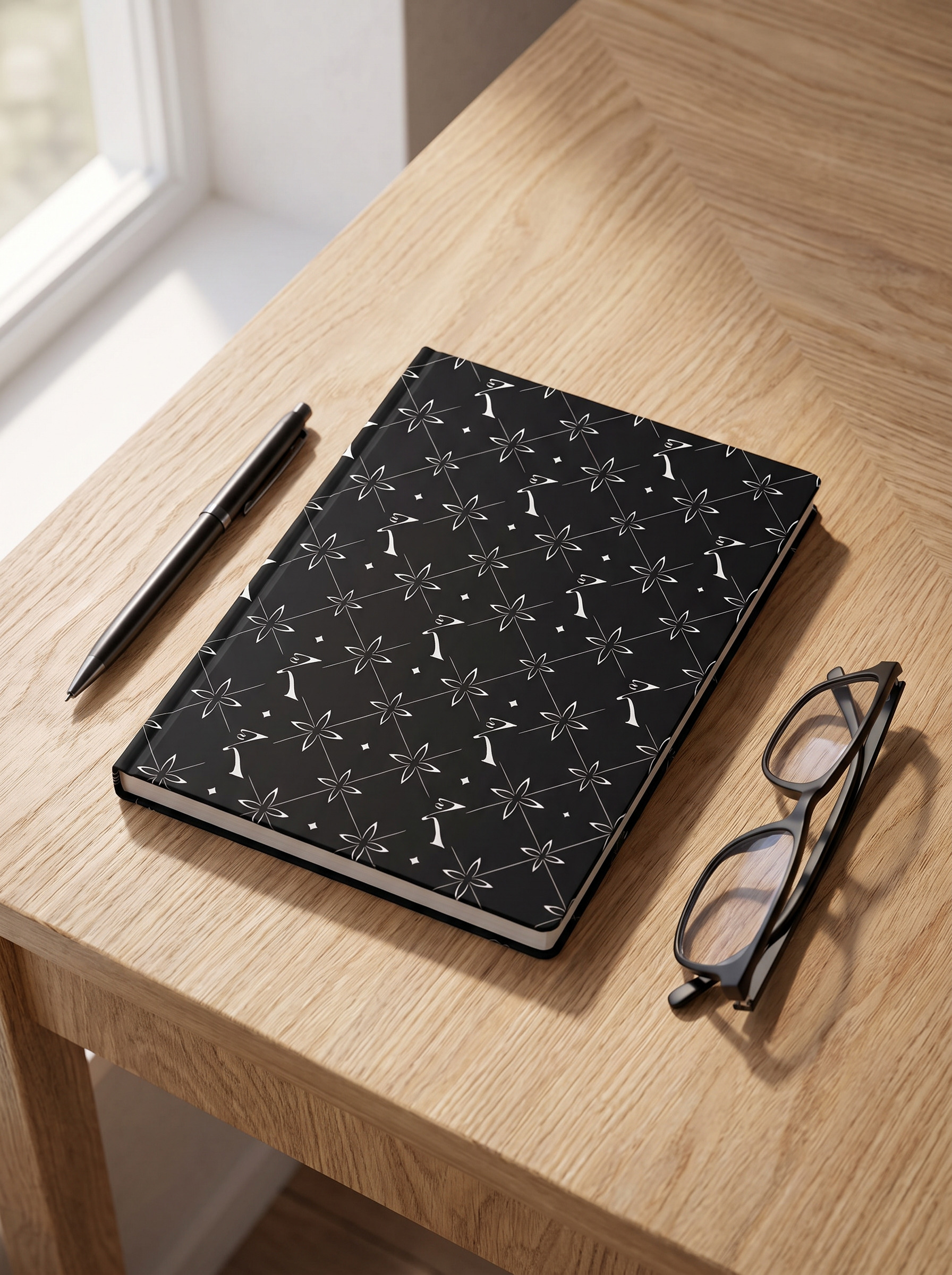 Original Notebook in Noor Black with the EKVAAR monogram, on a desk