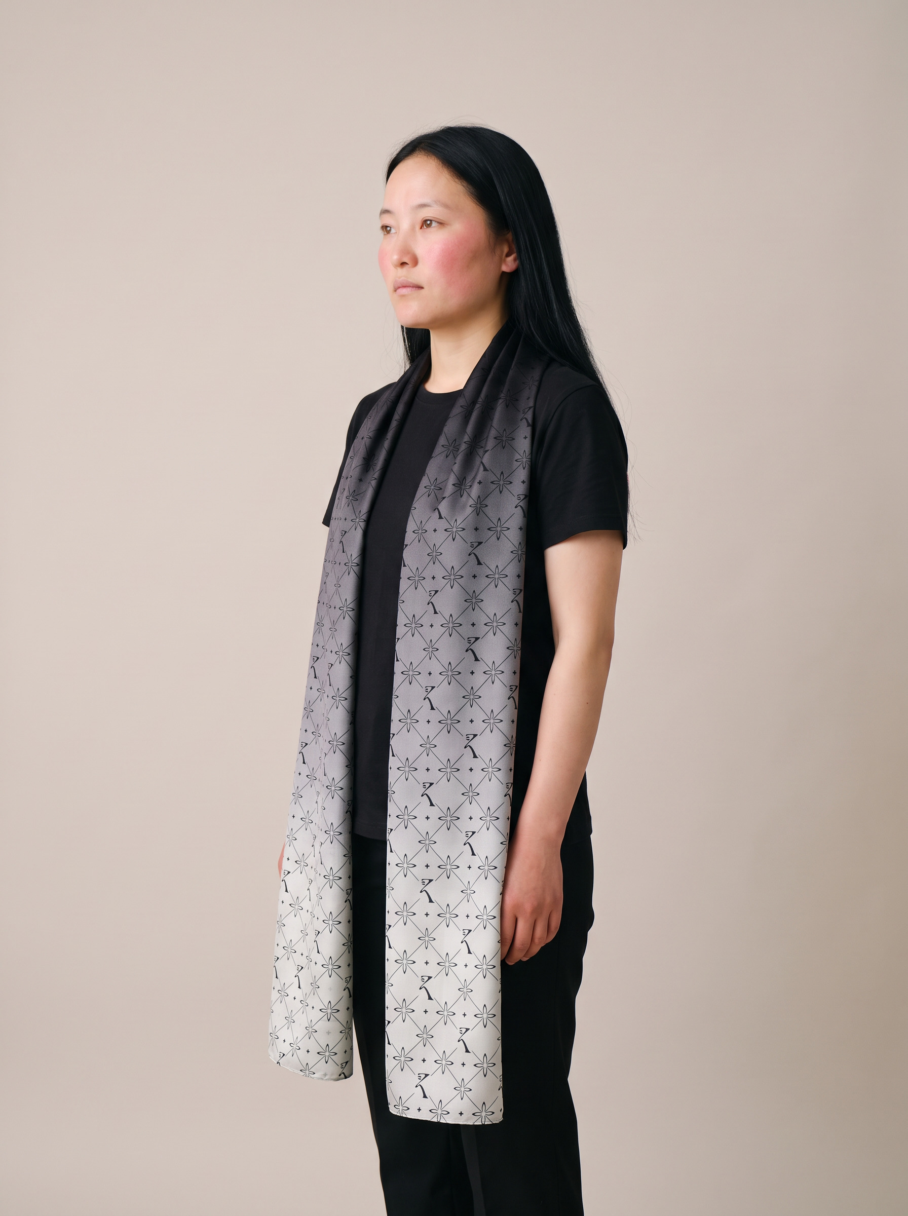 Original Stole in Noor Black with the EKVAAR monogram, worn by a model, one of three gifts for her that are not a tee