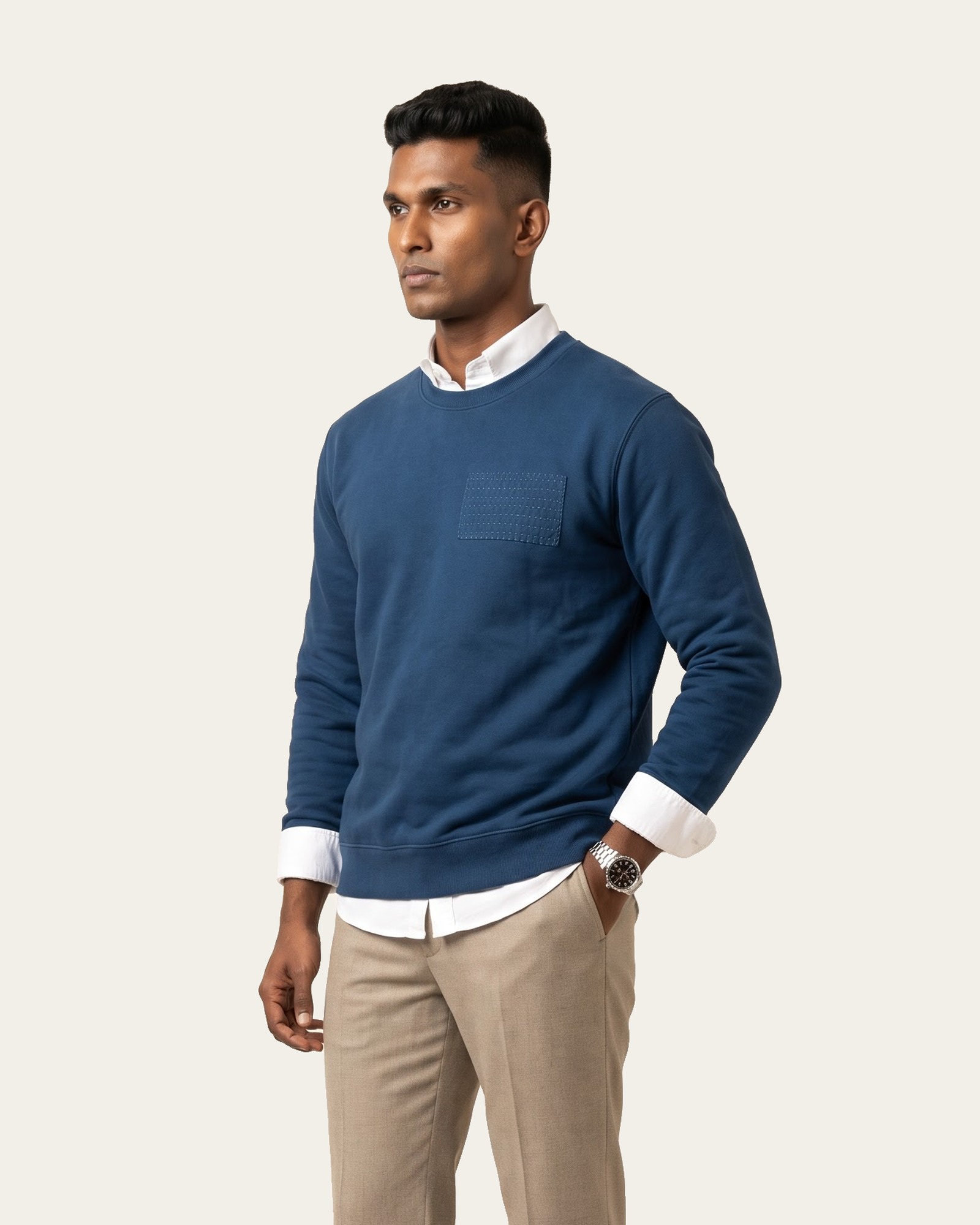 KANTHA ROWS sweatshirt in Neel Blue over a white shirt, with beige trousers